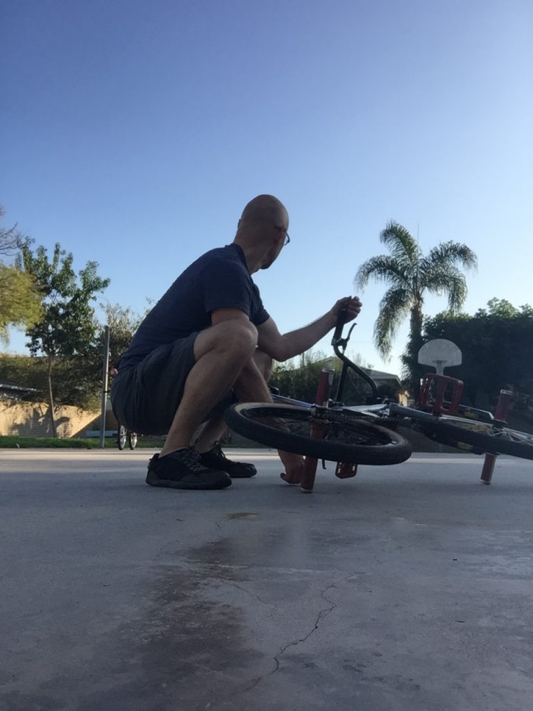scott squatting by his bike